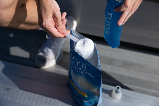 Portion de Carburant d'Endurance ELIXYR prélevée du sac pour remplir une gourde souple