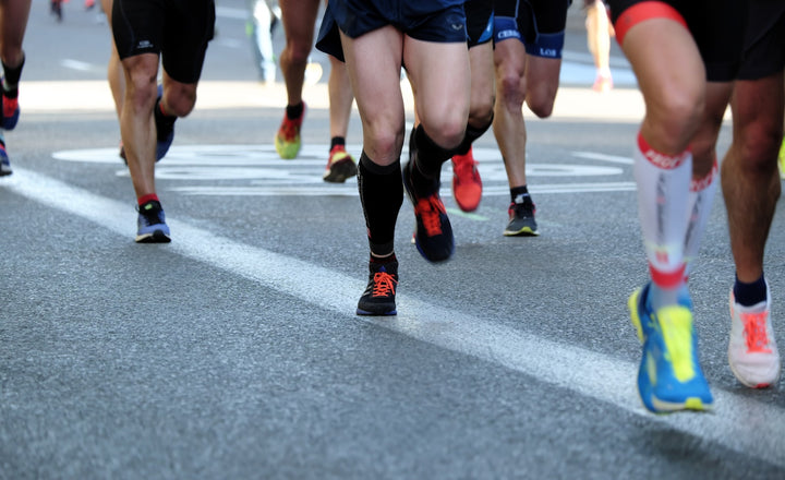 Coureur sur route, illustrant la gestion des glucides selon la distance de course