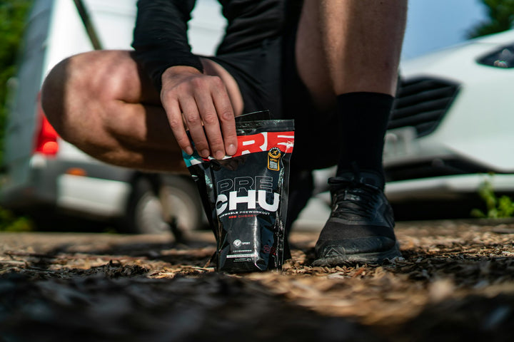 Coureur de trail ramassant un sachet de supplément énergétique au sol
